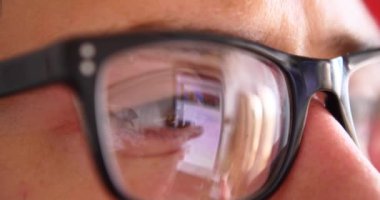 Sohbet yazarak, yansıma gözler gözlük yakın çekim smartphone kullanarak çekici genç adam.