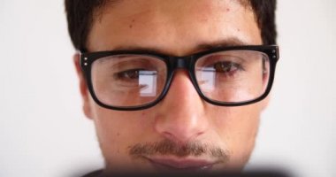 Sohbet yazarak, yansıma gözler gözlük yakın çekim smartphone kullanarak çekici genç adam.