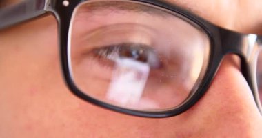 Sohbet yazarak, yansıma gözler gözlük yakın çekim smartphone kullanarak çekici genç adam.