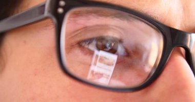 Sohbet yazarak, yansıma gözler gözlük yakın çekim smartphone kullanarak çekici genç adam.