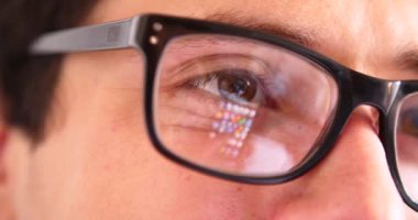 Sohbet yazarak, yansıma gözler gözlük yakın çekim smartphone kullanarak çekici genç adam.