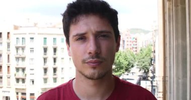 Balkon kameraya gülümseyen mutlu genç adam