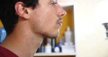 Bir elektrikli tıraş makinesi banyoda ayna önünde tıraş genç çekici adam