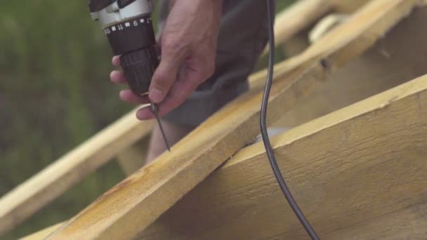 Arbeiter Dreht Die Schraube Das Brett Auf Dem Dach — Stockvideo