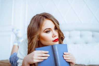 bir kitapla yatağa kadın