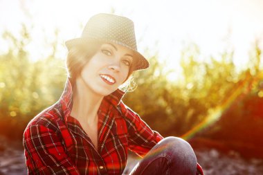 Gün batımında şapkalı ve gömlekli kız.