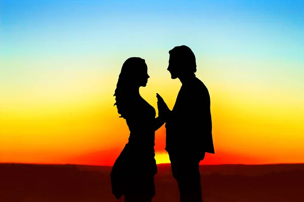 Silhouette di un ragazzo e una ragazza al tramonto — Foto Stock