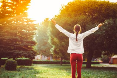 Parkta yoga egzersizi yapan güzel bir kadın.
