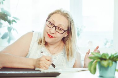 Yaşlı bir kadın ile bir kalem yazıyor