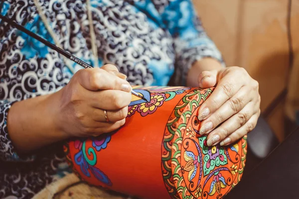 adam bir fırça ile ahşap üzerine çizer.