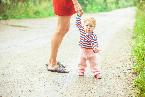 Het kind leert om op het gras te lopen — Stockfoto