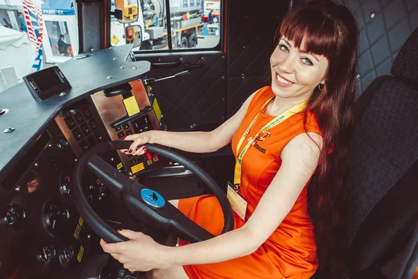 Новокузнецк, Россия, 5 июня 2018 года красивая девушка стоит у большого колеса. выставка оборудования . — стоковое фото