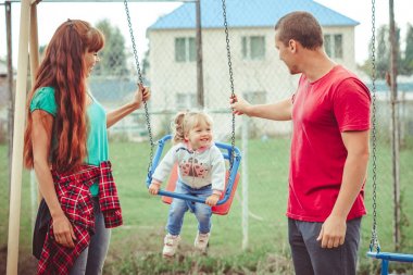 bir salıncak üzerinde sallanan bir çocuk
