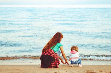 Anne ve kızı deniz kenarında.
