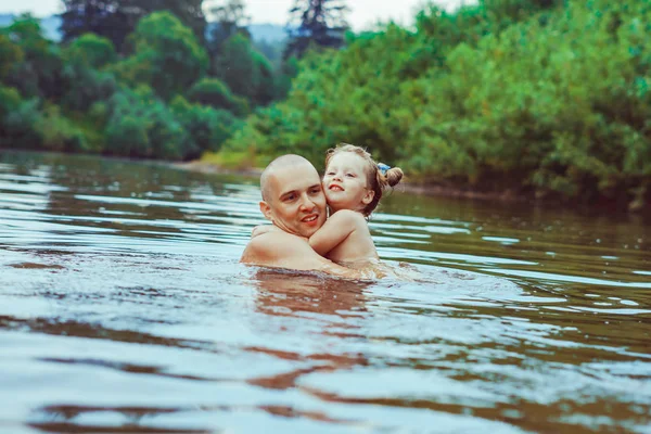 Dad and child bathe in the river