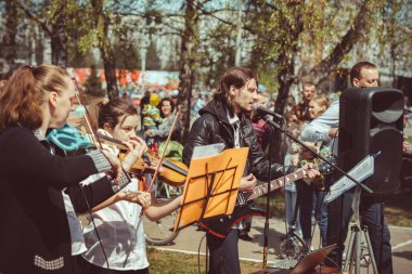 Rusya, Sibirya, Novokuznetsk - 9 Mayıs 2019: Müzisyenler sokakta şarkı söylüyor
