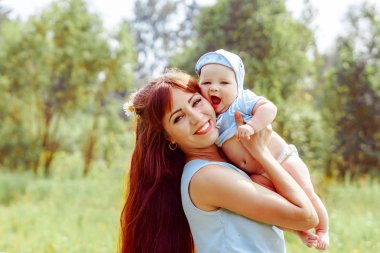 Anne kollarında çocuk yükseltir