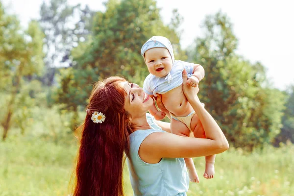 Mère élève l'enfant dans ses bras — Photo