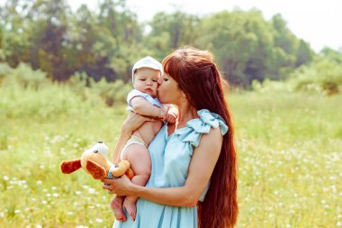 Anne kollarında çocuk yükseltir