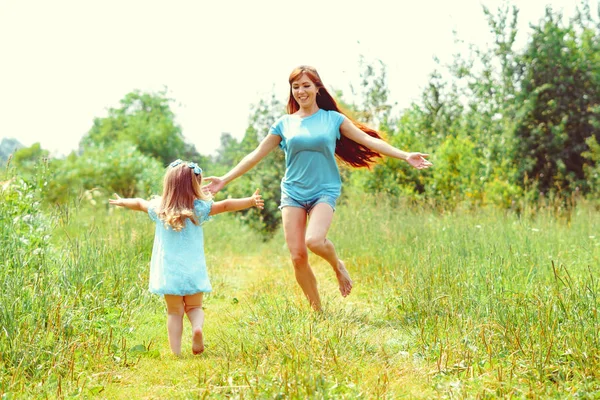 Dochter loopt naar haar moeder op het gras — Stockfoto