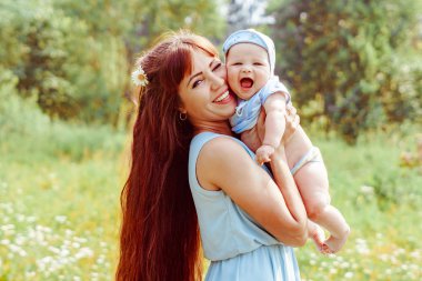 Anne kollarında çocuk yükseltir