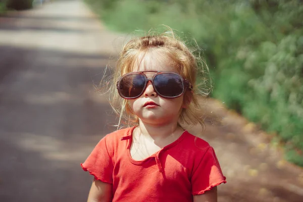 Retrato de una niña en gafas de sol en la naturaleza — Foto de Stock