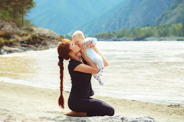 Maman élève l'enfant dans ses bras vers le haut — Photo