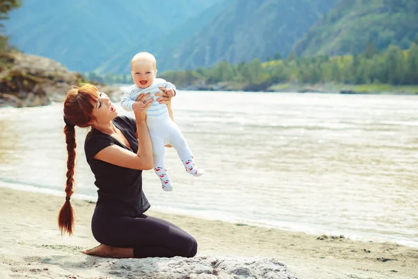 Mamma solleva il bambino tra le braccia — Foto Stock