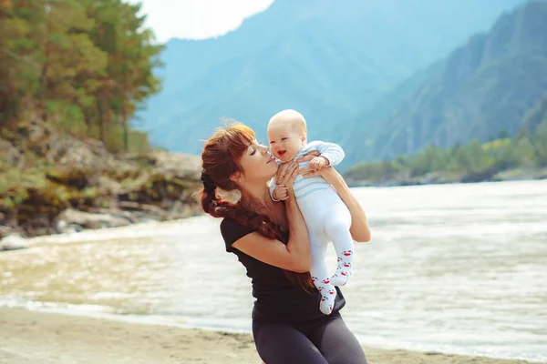 Mamma solleva il bambino tra le braccia — Foto Stock