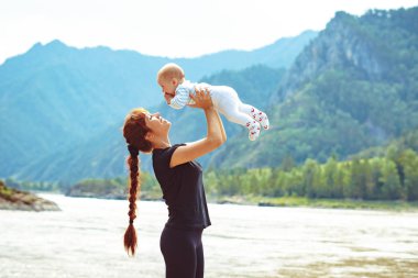 anne kollarında çocuk yükseltir