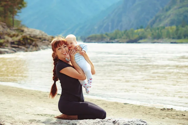 Anne kollarında çocuk yükseltir — Stok fotoğraf