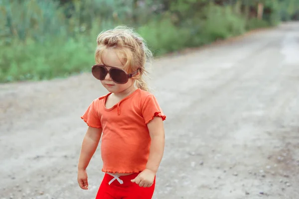 Portrait d'une petite fille en lunettes de soleil dans la nature — Photo