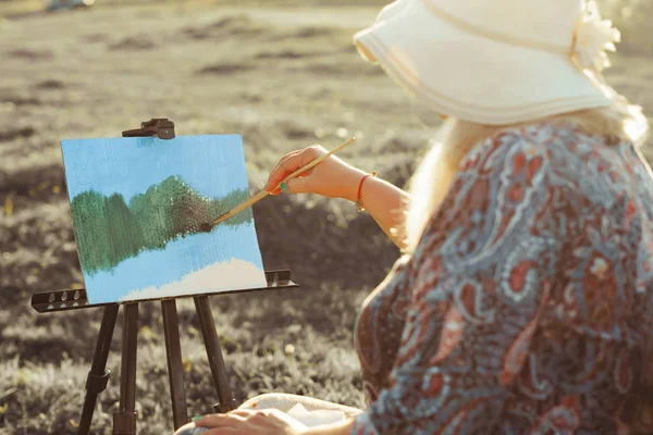 Yaşlı bir kadın doğada bir resim boyar — Stok fotoğraf