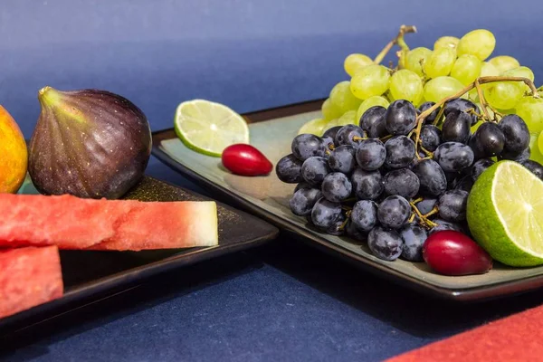 Frutas exóticas variedad bodegón con uvas, higos, lima, melocotón, mango y sandía — Foto de Stock