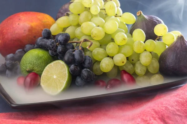 Frutas exóticas variedad bodegón con uvas, higos, lima, melocotón, mango y sandía — Foto de Stock