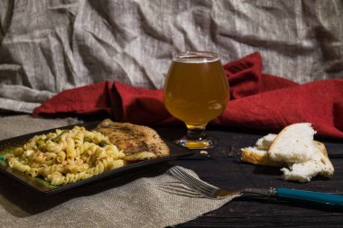 Lezzetli, sulu balık, bira ve ekmek ahşap arka plan ile makarna