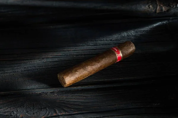 Cigar on old wooden table with blurred background — Stock Photo, Image