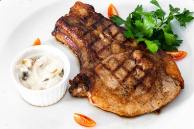 Sebzeli beyaz bir tabak içinde pirzola