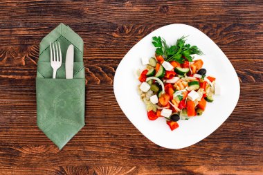 Taze salatalık, domates, tatlı biber, marul, kırmızı soğan, beyaz peynir ve zeytin zeytinyağı ile Yunan salatası. Sağlıklı gıda, cihazlar ile üstten görünüm