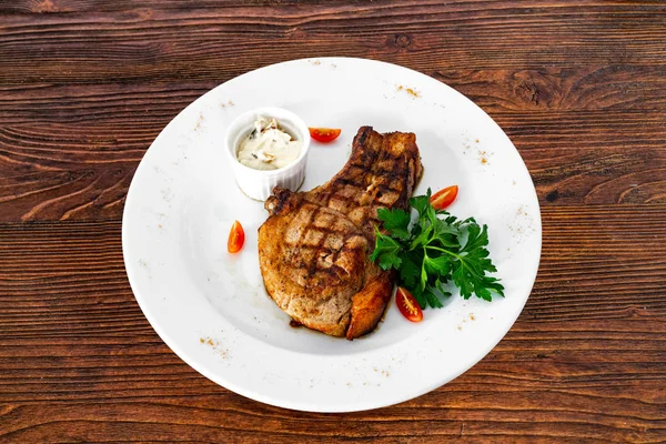 Chuleta de cerdo con verduras en un plato blanco —  Fotos de Stock