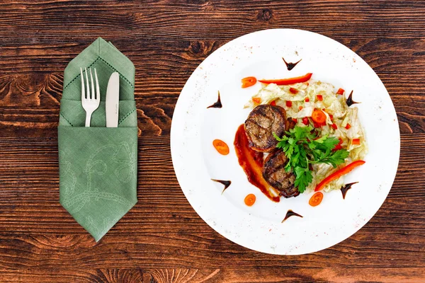 Súbdito de jugoso filete de medio carne a poco cocida con una salsa en un plato blanco con aparatos —  Fotos de Stock