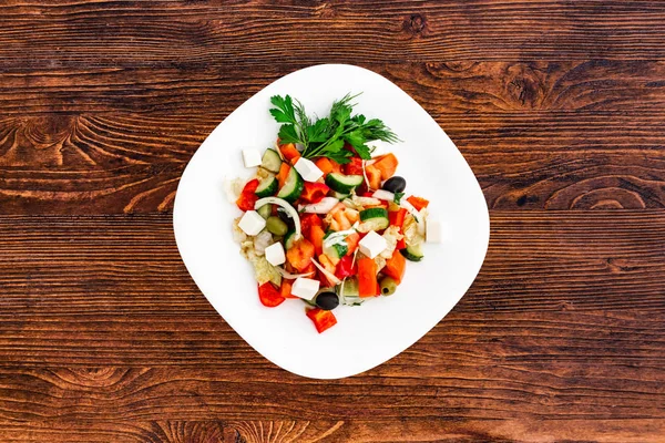 Greek salad of fresh cucumber, tomato, sweet pepper, lettuce, red onion, feta cheese and olives with olive oil. Healthy food, top view — Stock Photo, Image