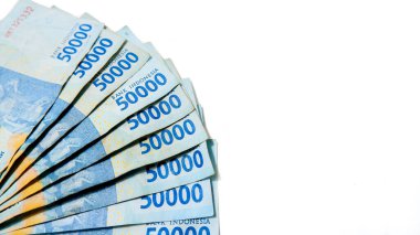 Endonezyalı bir hayranın yakından, yüksek açılı görüntüsü. Temiz beyaz arka planda 50,000 Rupiah banknotları.