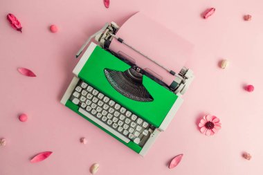 Pastel pembe çiçek desen arka plan en az yaratıcı kavramı karşı yeşil retro daktilo, düz yatıyordu.