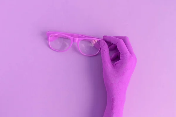 女性手持ち株の眼鏡 紫の色の最小限クリエイティブのコンセプト — ストック写真