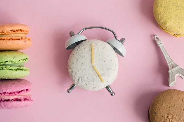 다채로운 Macarons와 파스텔 배경에 미니어처 모델의 플랫이 시계와 바늘의 모양에 — 스톡 사진