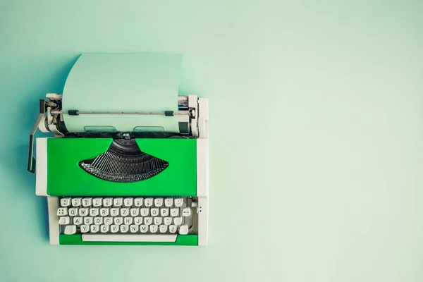 テーブルの上の空白の紙のシートと緑のヴィンテージ タイプライターの平面図です コピーのためのスペース — ストック写真