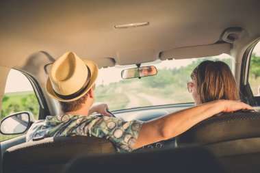 Arkadan Görünüş güzel çift arabada oturuyor. Seyahat kavramı keyfi.