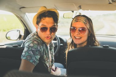 Arabada oturan ve kollamaya güzel genç bir çift. Kavramı bu yolda seyahat.
