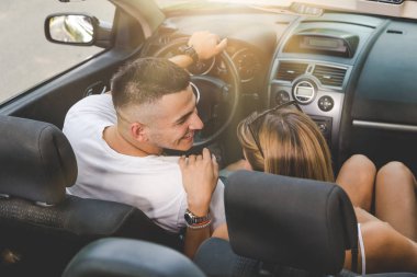 Güzel genç çiftin cabriolet arabada oturan yüksek açılı görünüş.